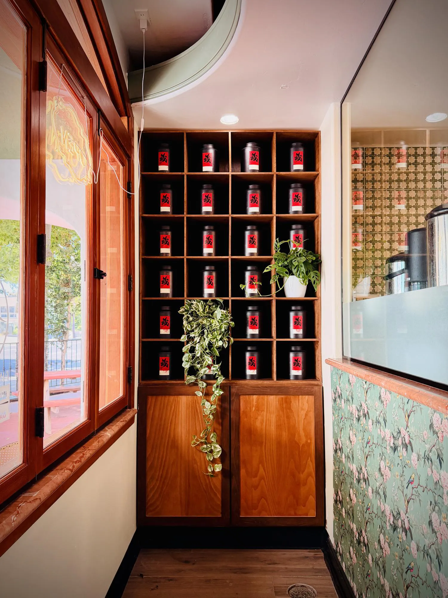 Decorative Tea Canister Display with Wooden Shelving and Floral Interior Design Elements